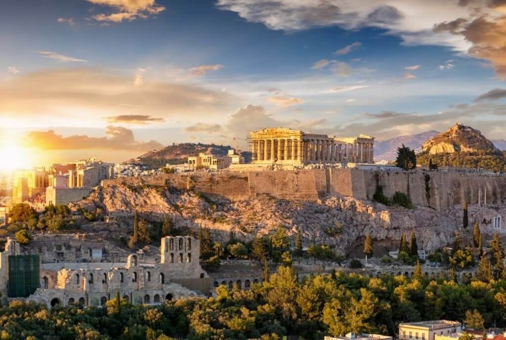 Yunanistan'ın Atina şehrinde yer alan tarihi Akropolis. Gün batımında ışıldayan antik tapınaklar, şehre büyüleyici bir manzara sunuyor.