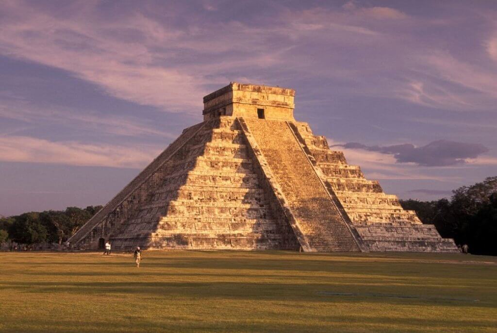 Meksika'da yer alan antik Chichen Itza piramidi. Gün batımında parlayan bu tarihi yapı, Mayaların görkemli geçmişini gözler önüne seriyor.